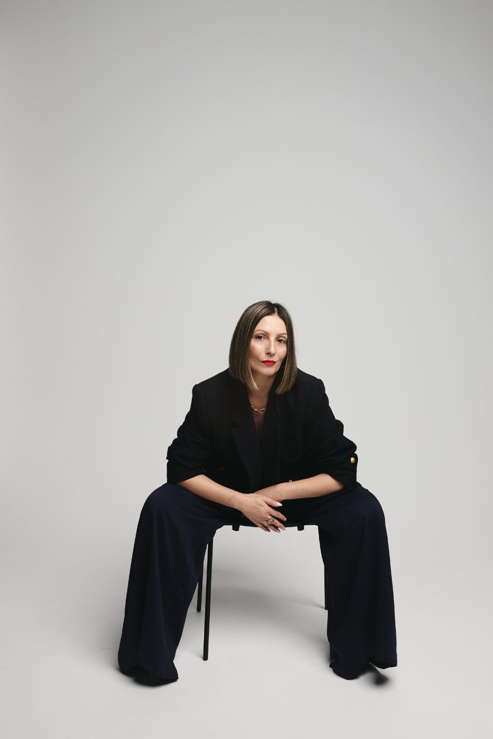 Roberta Lee - Sustainable Stylist with Values - London. Seated in powerful position wearing sustainable clothes in Navy. Elegantly styled.