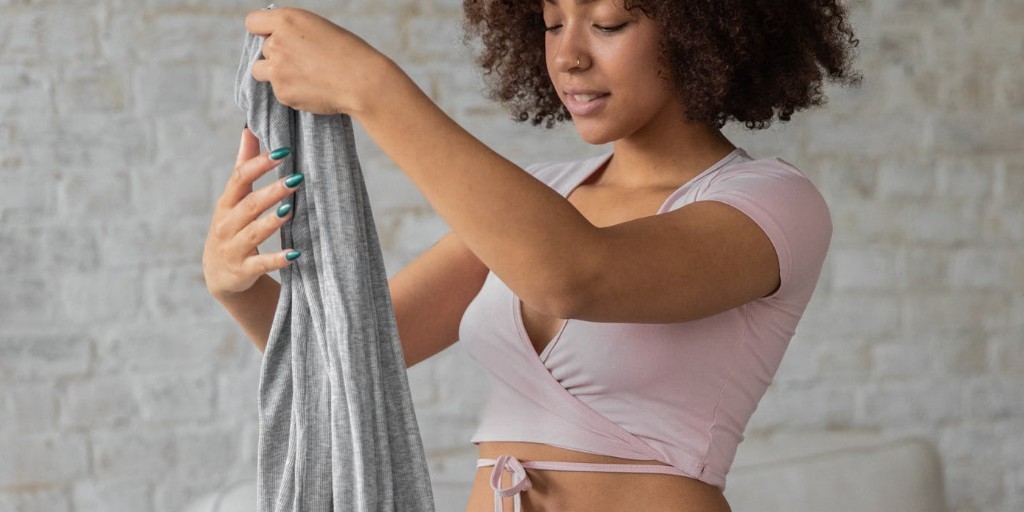 Woman folding clothes | Benefits of a closet detox