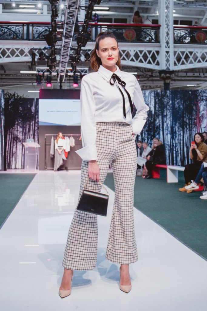 SEO Alt Text: Model Amanda Sarco Styled By Roberta Lee, Pure London Runway Feb 2020 | Conscious Fashion Brands | White T-Shirt, Check Trousers, Black Bag