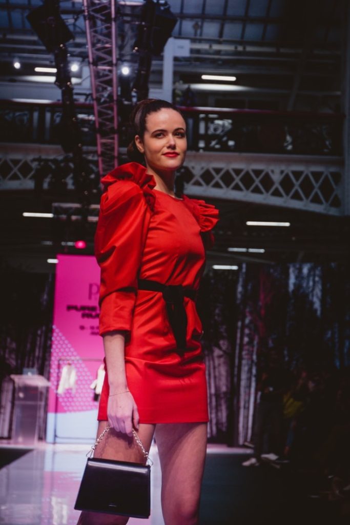 SEO Alt Text: Model Amanda Sarco Styled By Roberta Lee, Pure London Runway Feb 2020 | Conscious Fashion Brands | Red Dress, Black Clutch Bag
