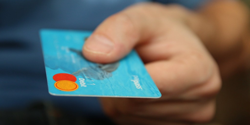 Holding a credit card | What is Cost per Wear? | Wardrobe Investments | Sustainable Closet Tips