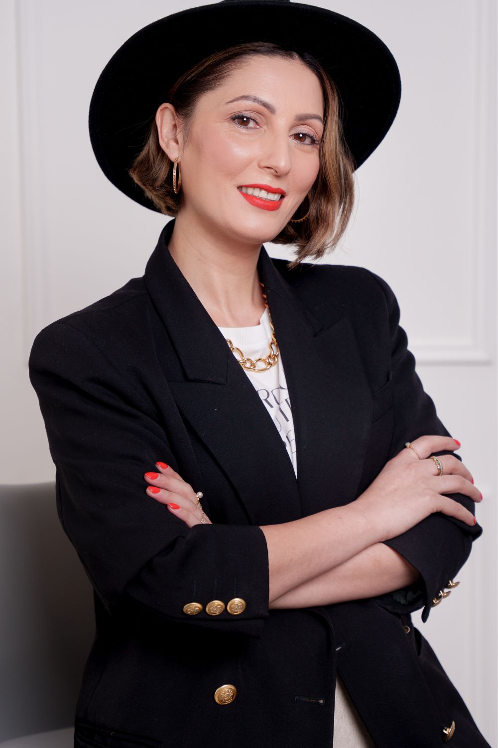 Roberta Lee, sustainable stylist standing with her arms crossed wearing a vintage blazer and hat.