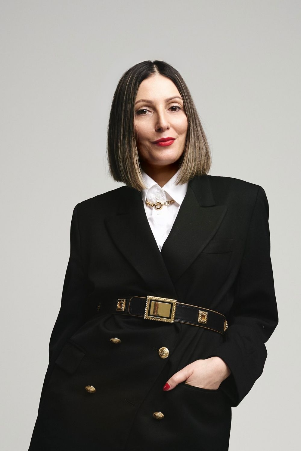 Roberta Lee The Sustainable Stylist wears a blazer, vintage belt, white shirt and gold chunky chain.